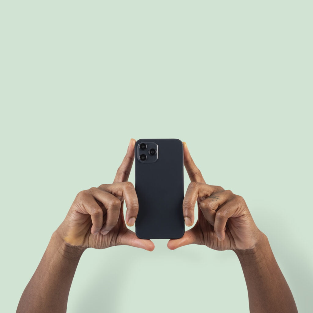 schwarzes Smartphone vor hellgrünem Hintergrund