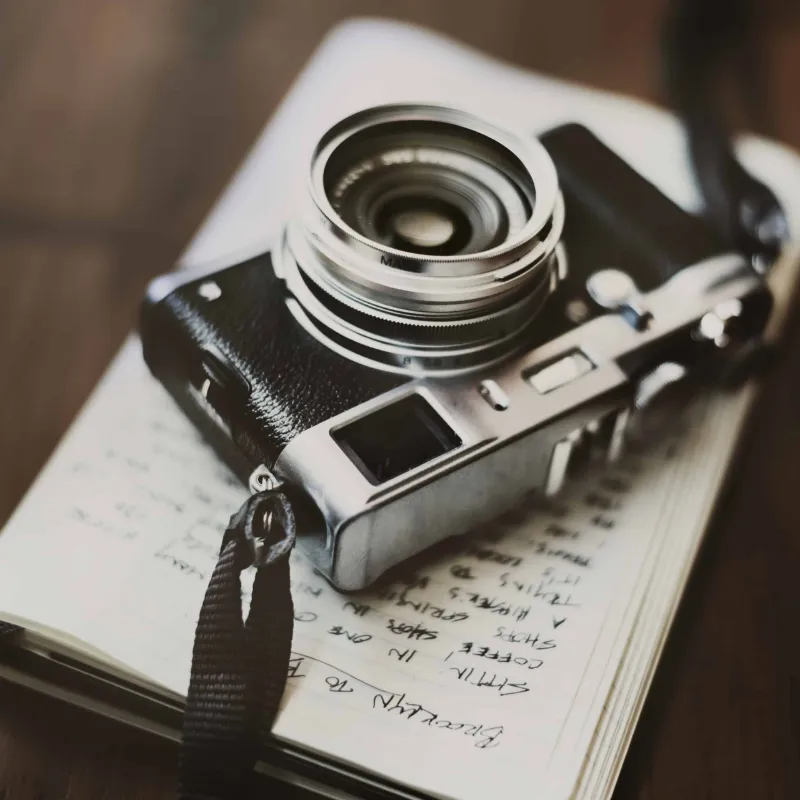 Nahaufnahme eines alten Kleinbild Fotoapparates, der auf einem Notizbuch liegt.
