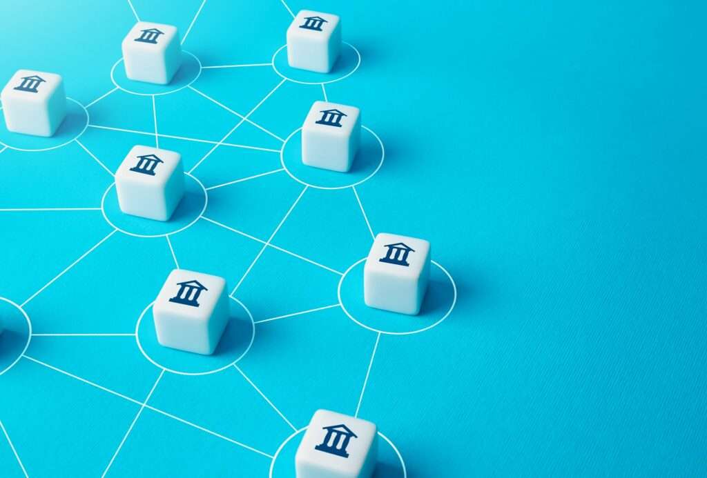 Suchmaschinenoptimierung Hannover - Bild von weißen Würfeln mit Bankgebäudesymbolen, die durch Linien auf einem blauen Hintergrund verbunden sind und ein von der Webagentur Hannover entworfenes Netzwerk oder System darstellen. Local SEO Agentur Hannover.