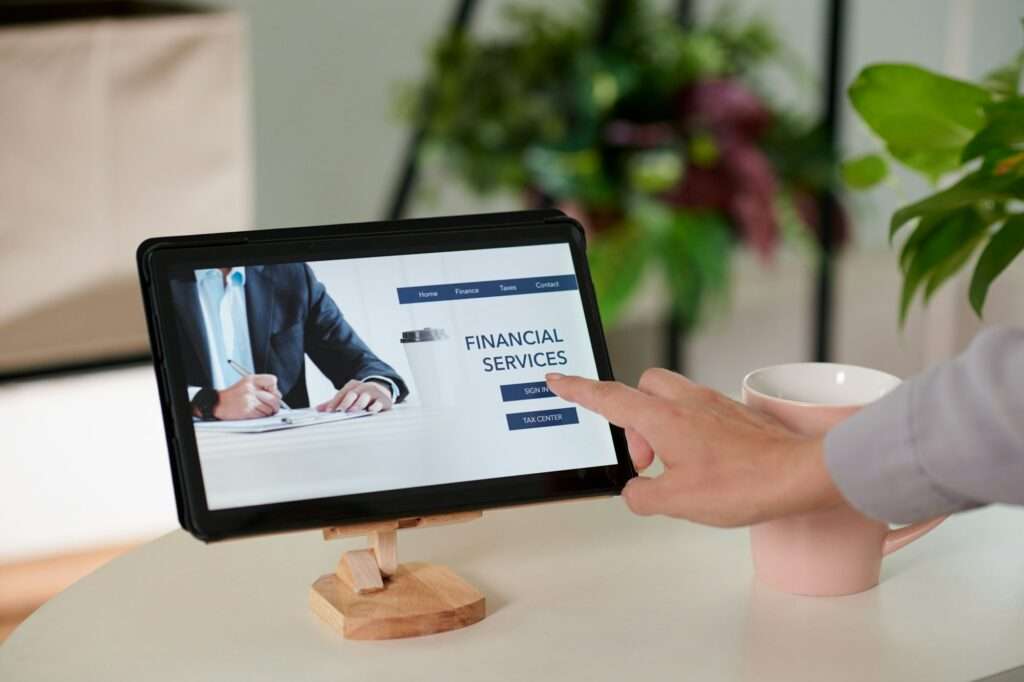 Hand of young businesswoman pointing at homepage on tablet screen