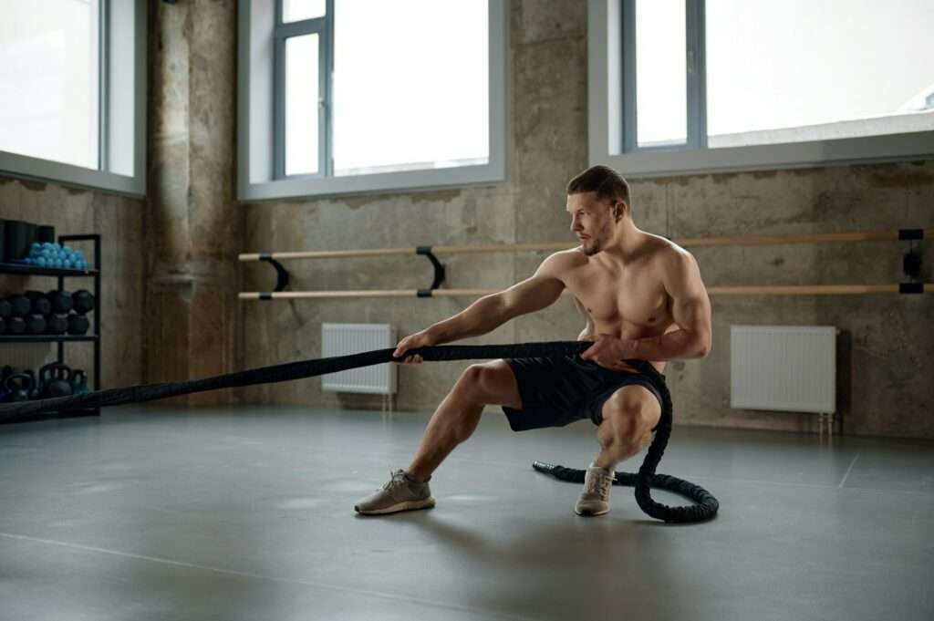 A strong man pulling training sports rope front view