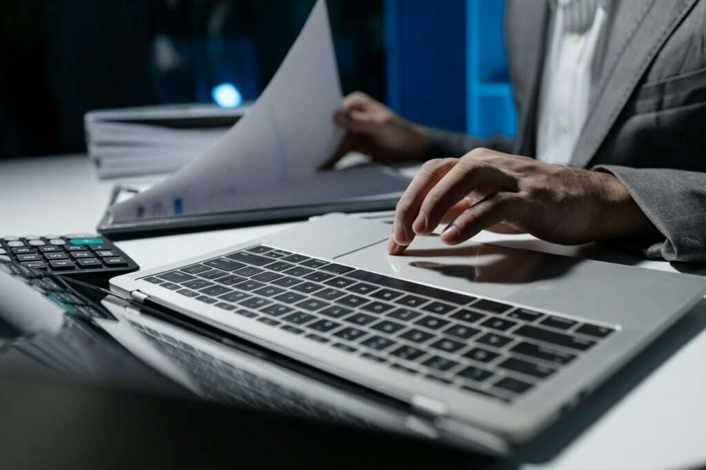 A young businessman is using a laptop to search for important information on business competitors, A