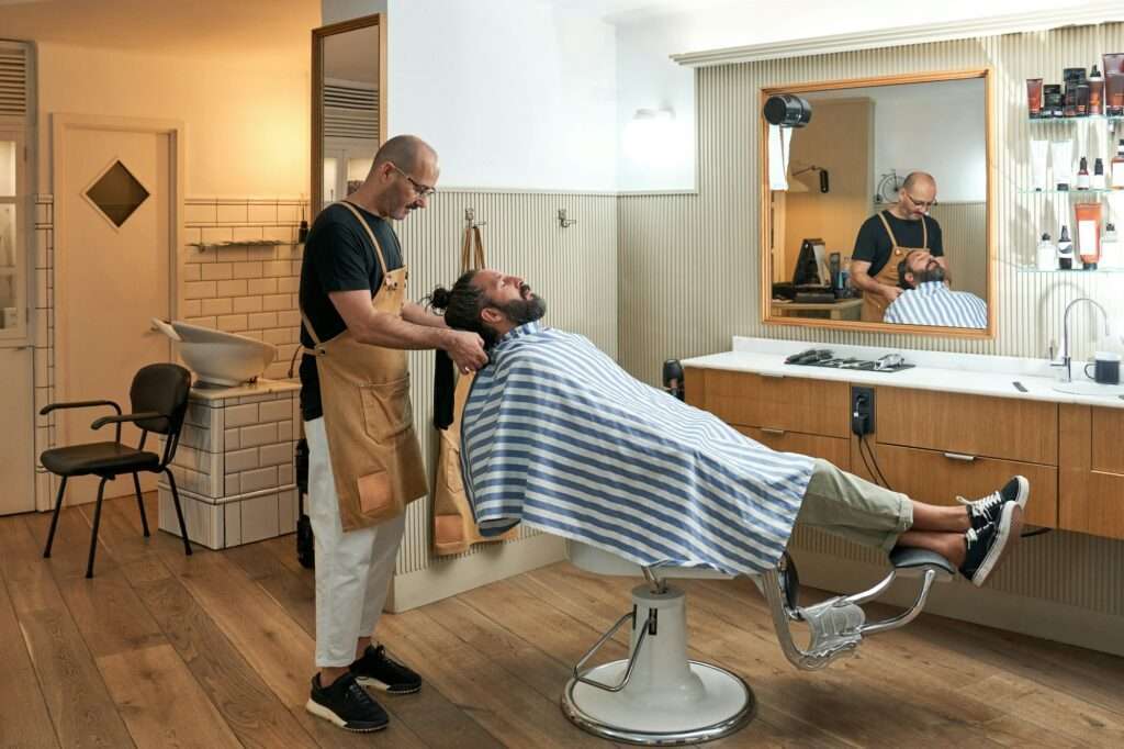 Barber combing hair of client in barbershop