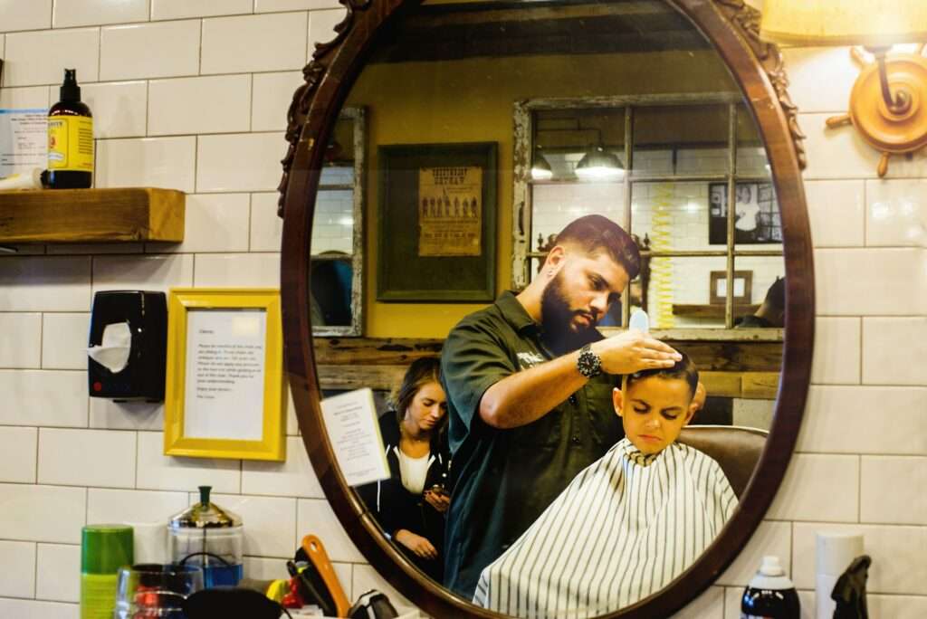 Barber shaving boy's hair