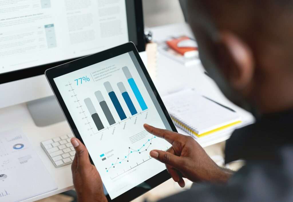 Businessman using digital tablet computer with financial data on screen in office