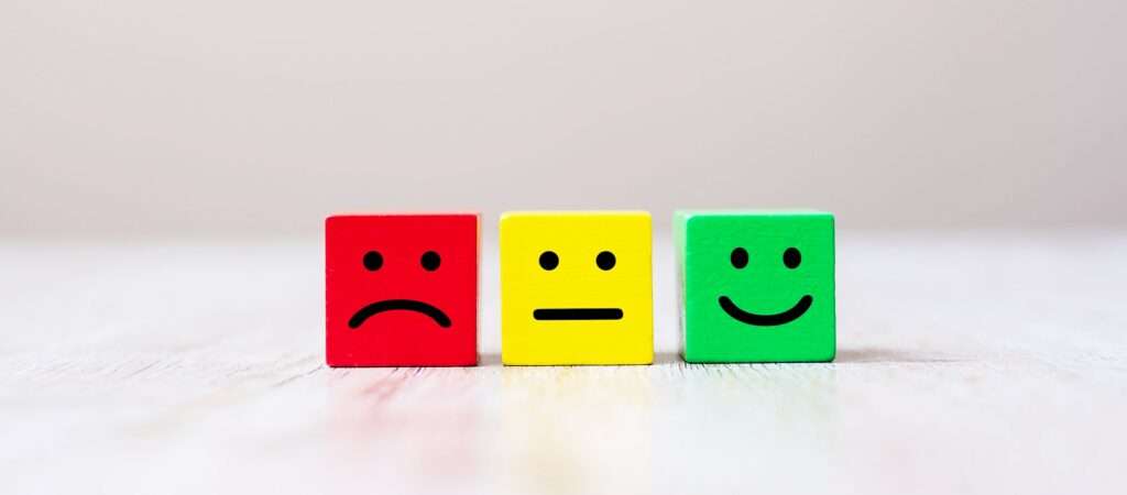 Emotion face symbol on yellow wooden cube blocks. Service rating, ranking, customer review