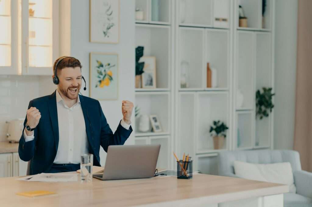 Excited successful businessman enjoying triumph with clenched fists