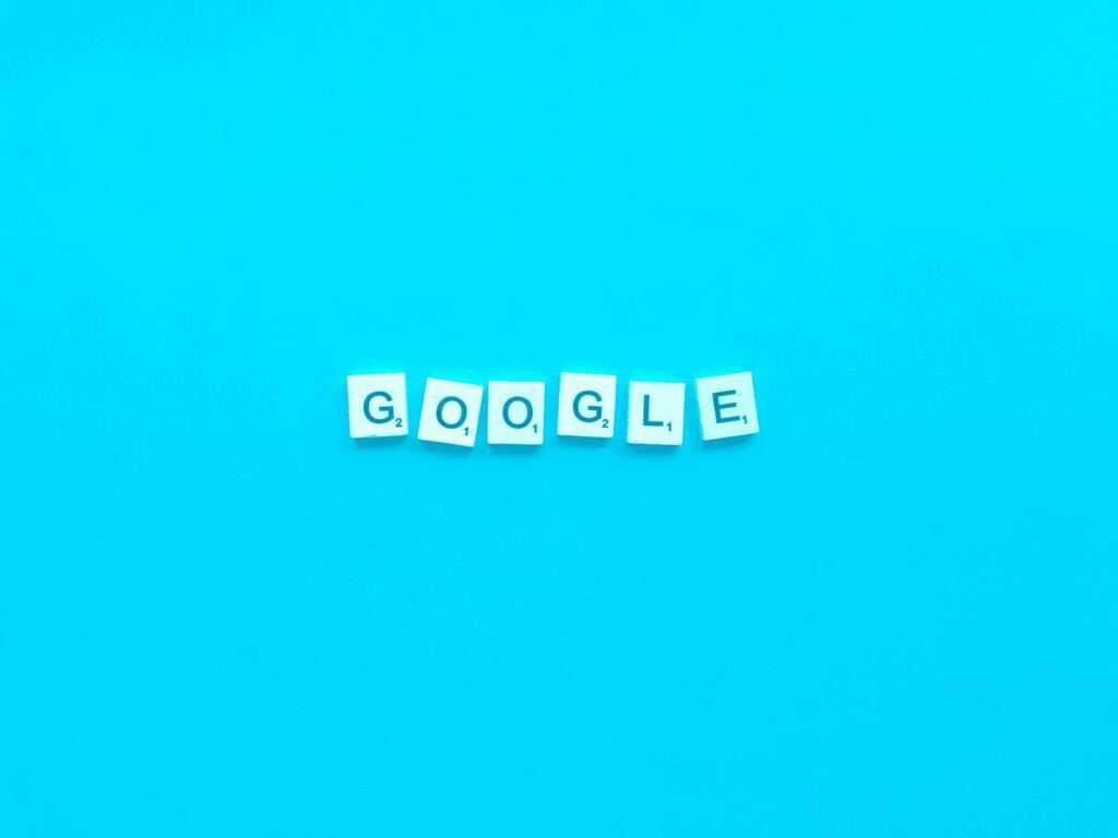 SEO Hannover - Sieben Scrabble-Steine mit dem Wort „GOOGLE“ sind in einer Reihe auf einem hellblauen Hintergrund angeordnet und erinnern an eine bunte Google-Ergebnisliste. Local SEO Agentur Hannover.