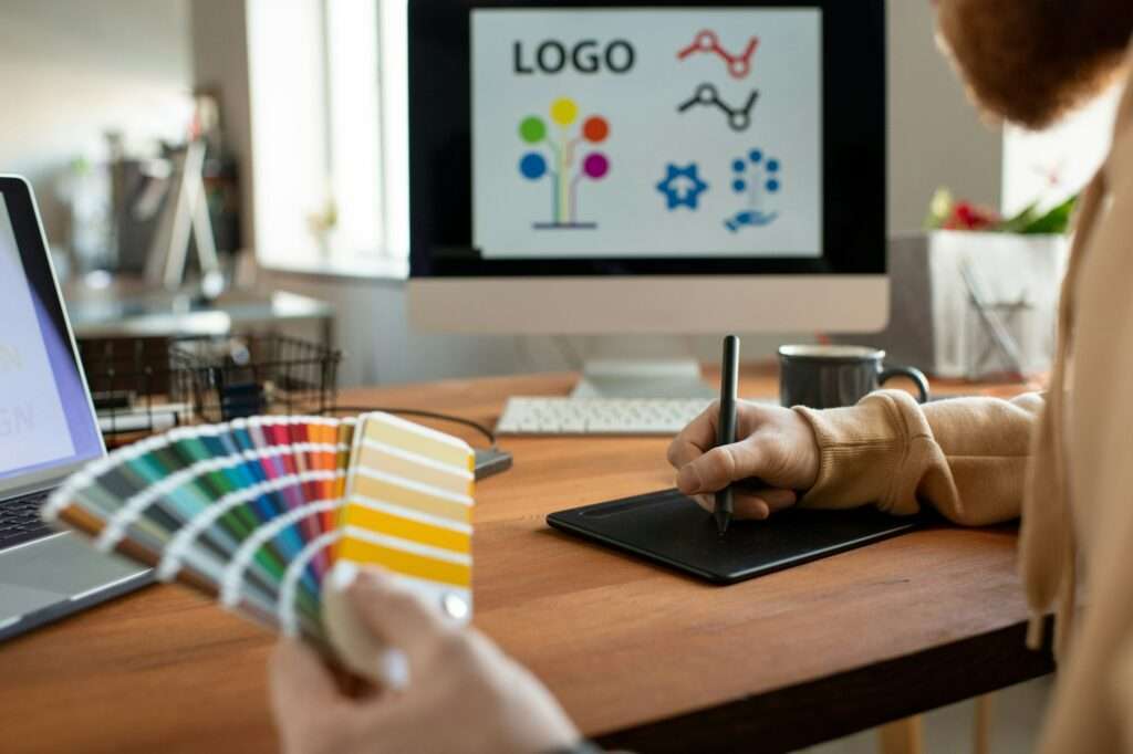 Hands of creative male freelance designer choosing colors from palette at work