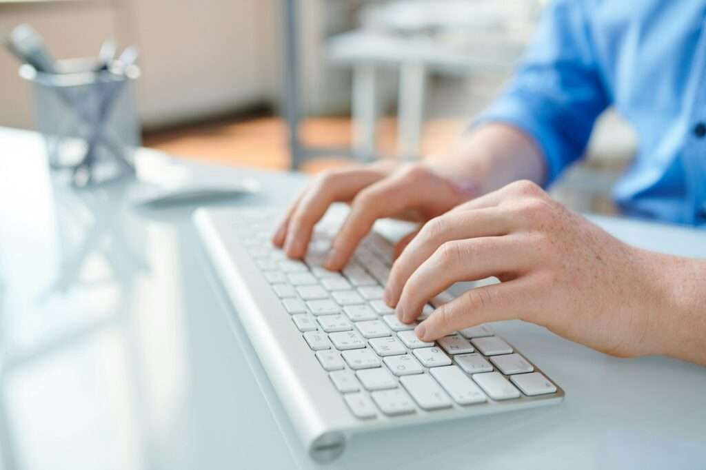 Hands of creative webdesigner touching keys of desktop keypad