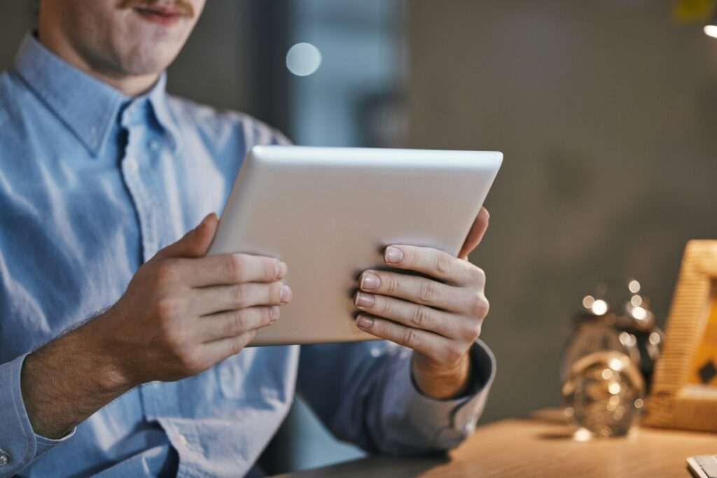 Hands, tablet and office with businessman in night for web design, planning and development of app.