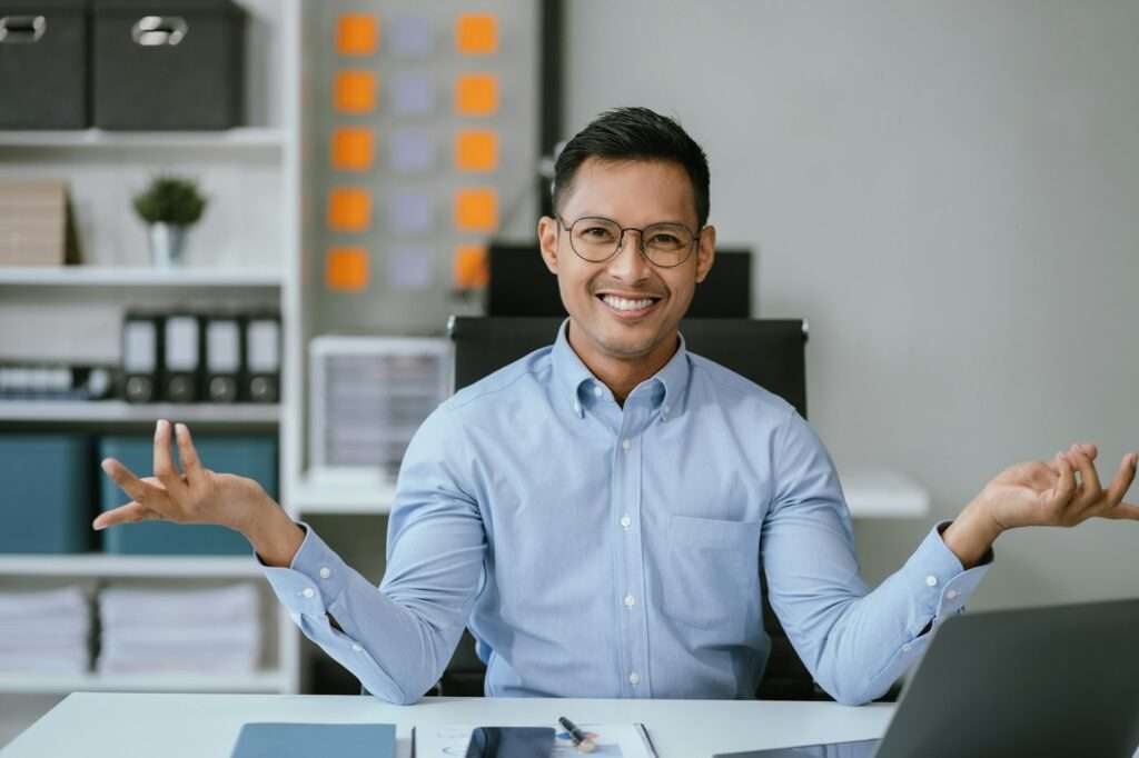 Happy young asian man presenting or showing open hand palm, happy working.