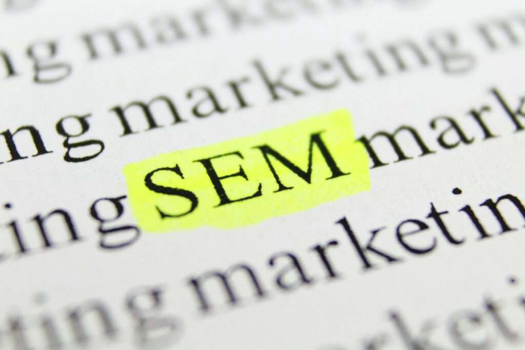 SEO Hannover - Das Bild zeigt das Akronym „SEM“ in gelber Farbe auf einer gedruckten Seite. Der umgebende Text enthält „Marketing“, was darauf hindeutet, dass der Schwerpunkt im Kontext des Dokuments auf Suchmaschinenmarketing liegt, und die Frage aufwirft: Was versteht man unter SEM? Local SEO Agentur Hannover.