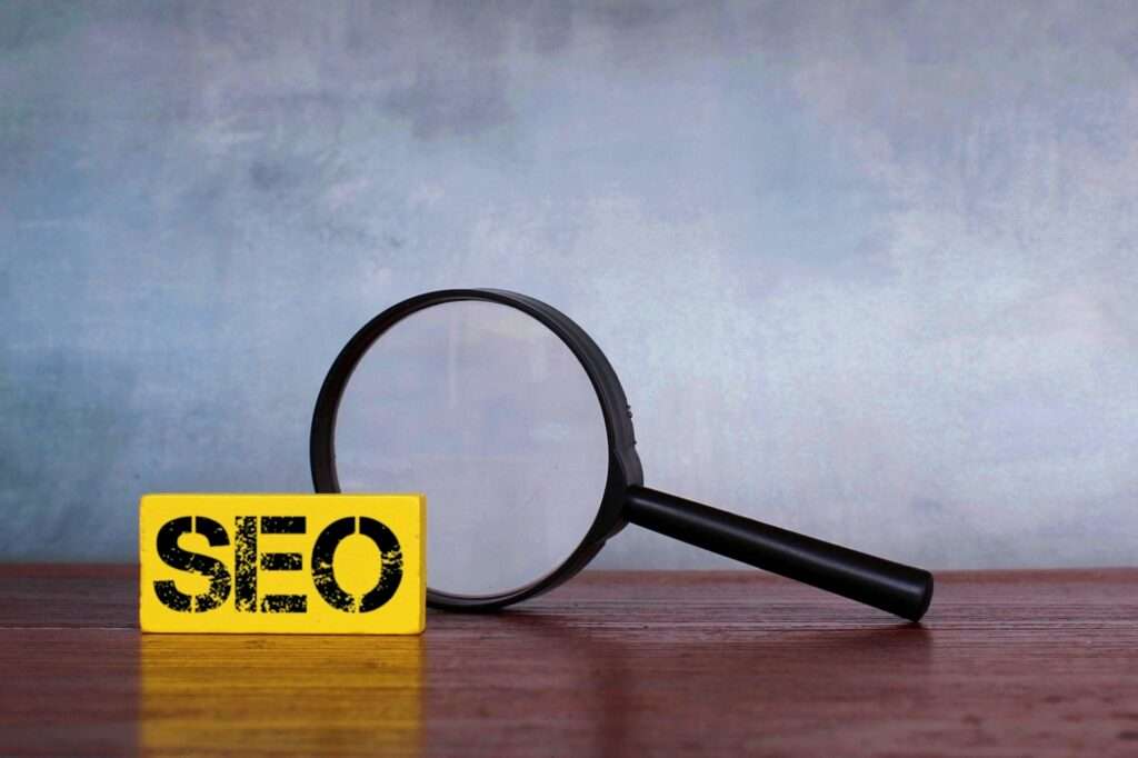 Magnifying glass and wooden cube with text SEO