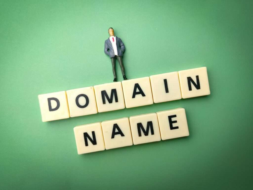 Miniature people and toys word with the word DOMAIN NAME