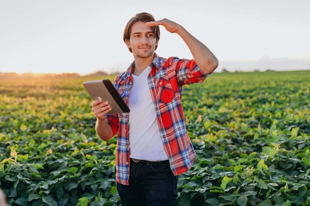 Portrait of agronomist standing in field with a ipad and looking fa from. -Image