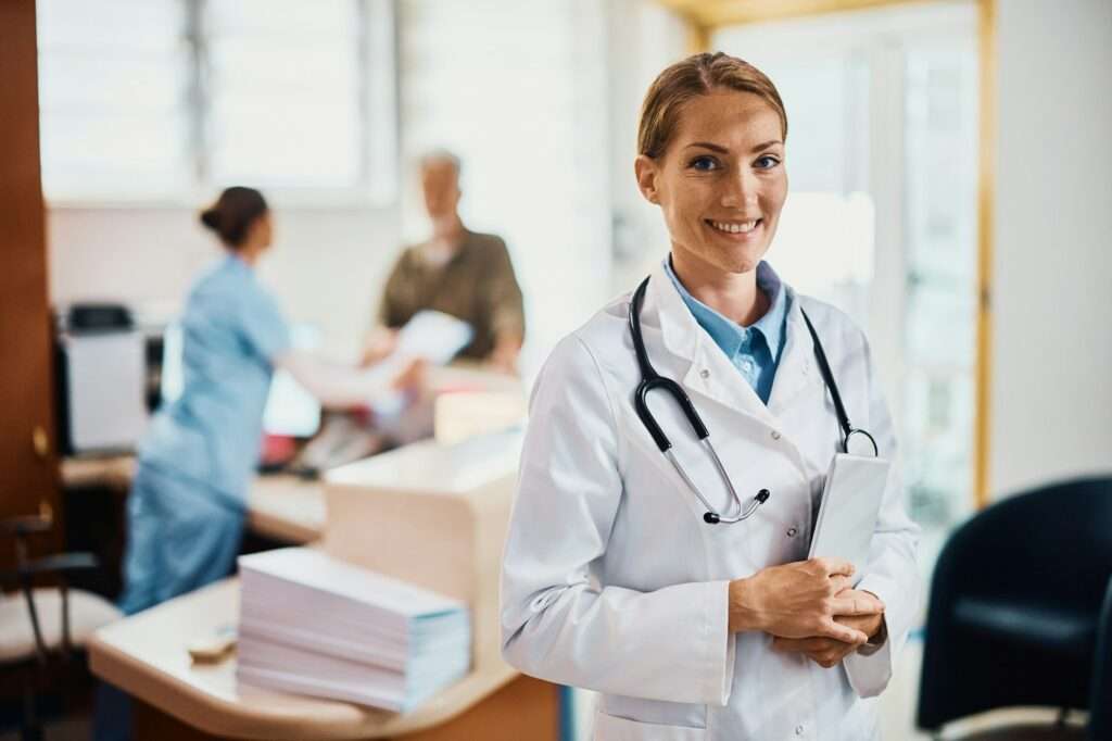 Portrait of happy female doctor at medical clinic looking at camera.