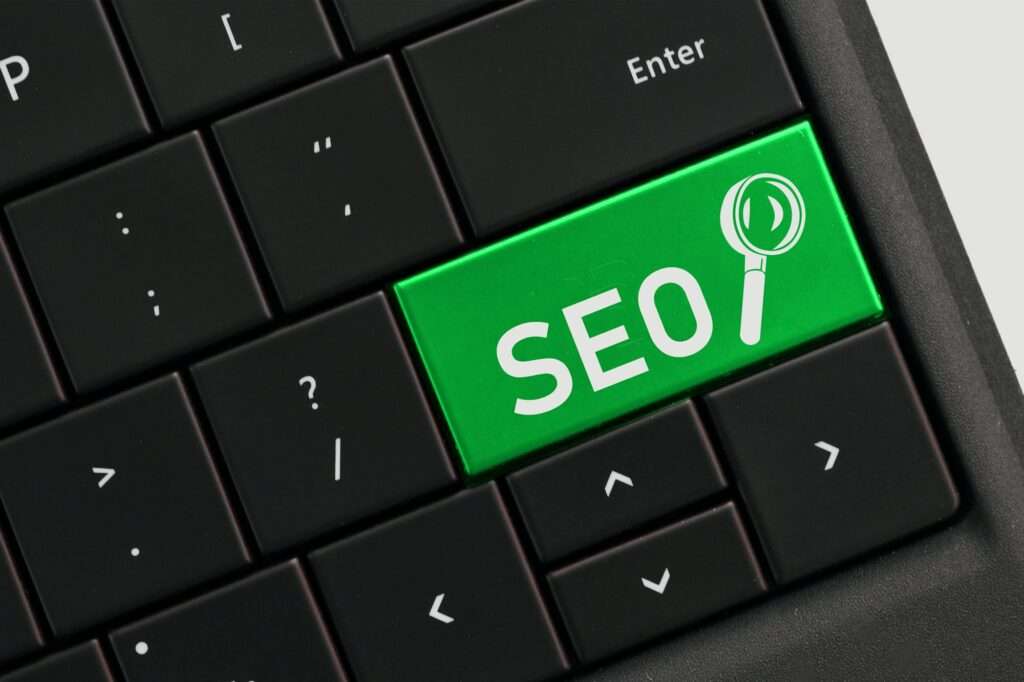 SEO Hannover - Eine Nahaufnahme einer Computertastatur vor schwarzem Hintergrund. Eine Taste ist grün hervorgehoben und trägt die Buchstaben „SEO“ und ein Lupensymbol, das Google SEO und Suchmaschinenoptimierung symbolisiert. Local SEO Agentur Hannover.