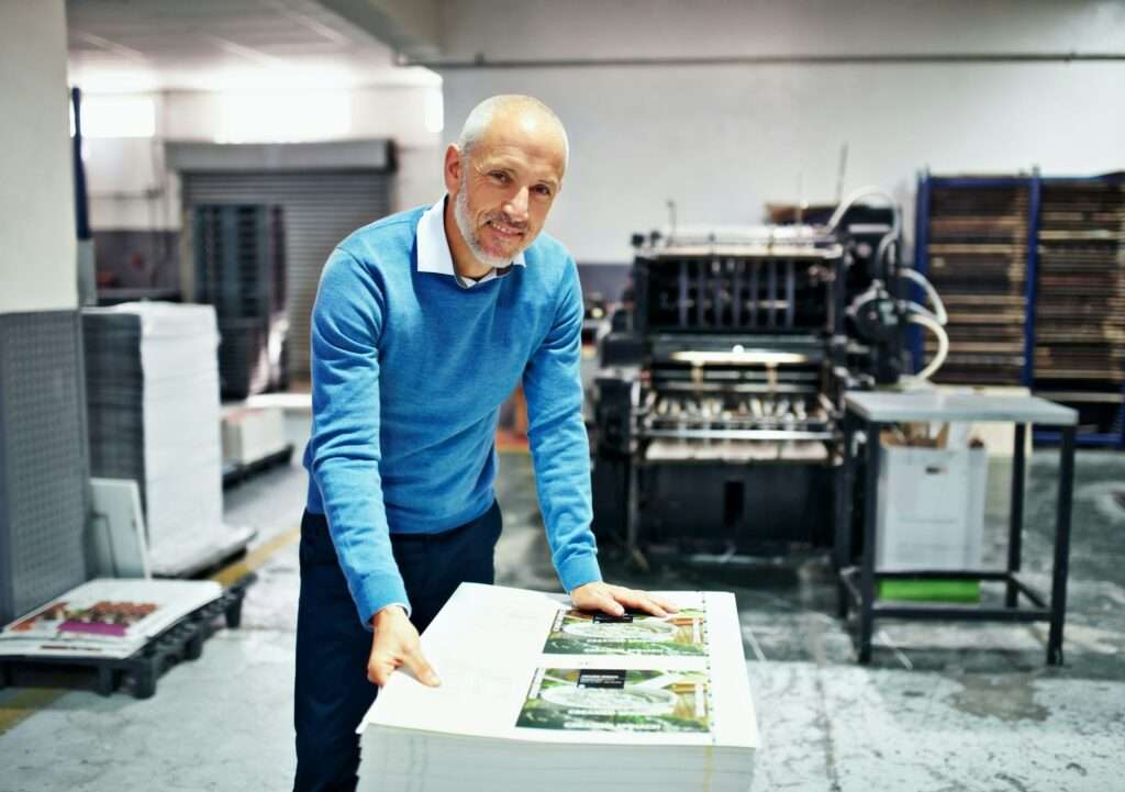 The product is my reputation. Portrait of a man checking the quality of a print run in a factory.