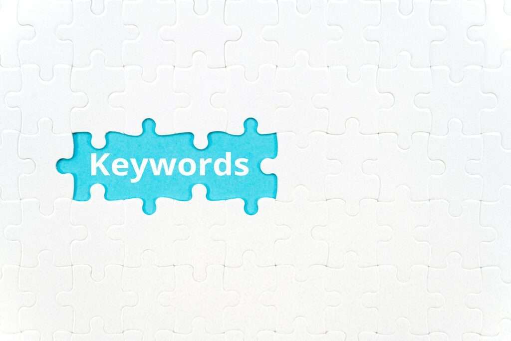 SEO Hannover - Bei einem Puzzle, das überwiegend aus weißen Teilen besteht, fehlt ein Teil, sodass ein hellblauer Hintergrund mit den weißen Worten „Was sind Keywords“ sichtbar wird. Local SEO Agentur Hannover.