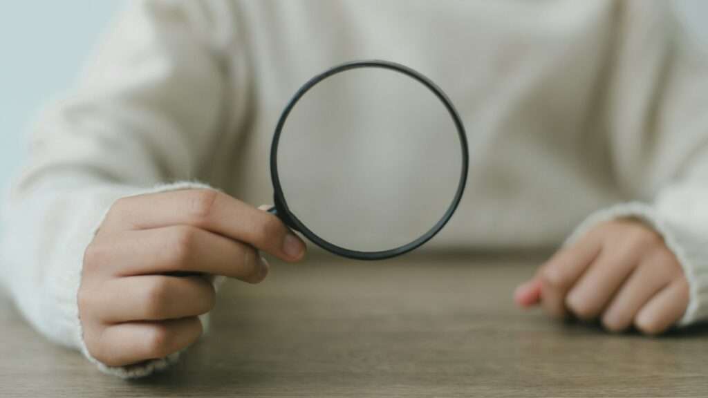 Woman holding magnifying glass, closeup. Find keywords concept