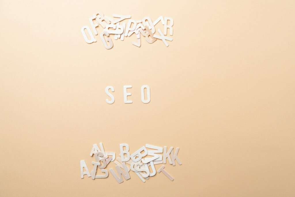 SEO Hannover - Das Bild zeigt die fettgedruckten Buchstaben „SEO“ zentriert vor einem beigen Hintergrund und erinnert damit an die Essenz von Google SEO. Über und unter „SEO“ sorgen verstreute weiße Buchstaben für ein faszinierendes Chaos in der Szene. Local SEO Agentur Hannover.