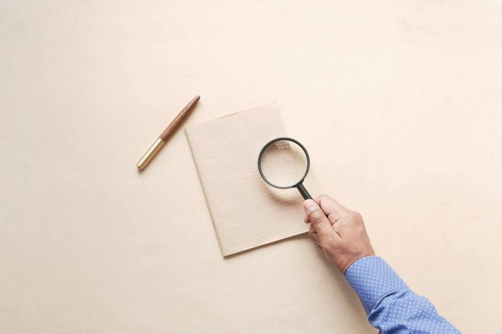 hand in magnifying glass inspecting 404 error.