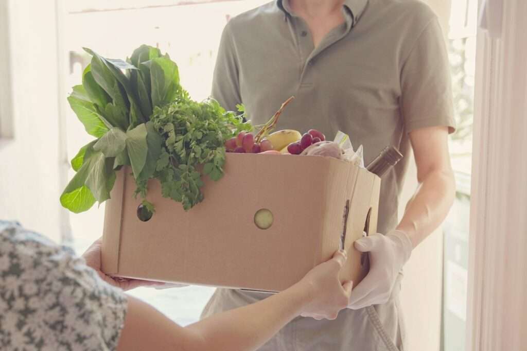 man holding grocery food box for donation,home delivering, supporting local business concept