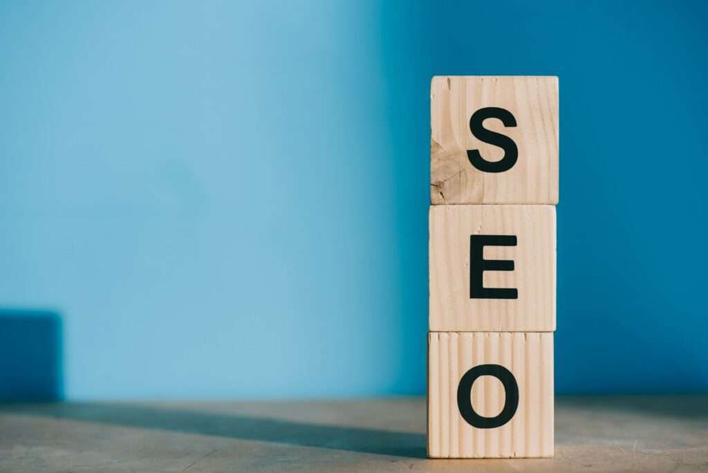 SEO word made from wooden blocks on blue background