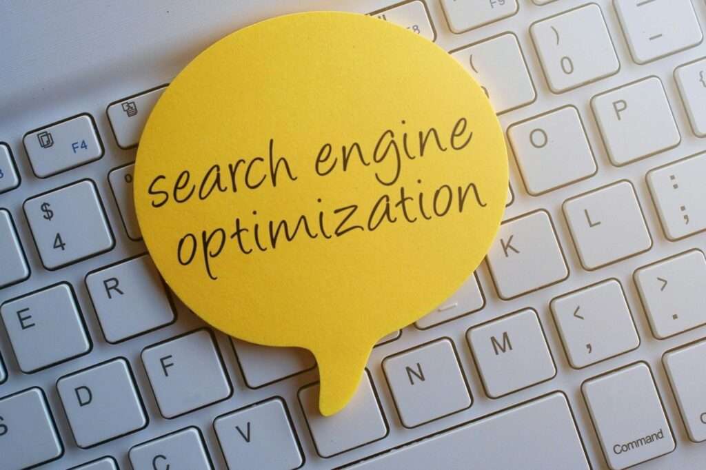 SEO Hannover - Ein gelber Zettel in Form einer Sprechblase mit der Aufschrift „Suchmaschinenoptimierung“ liegt auf einer weißen Tastatur und verdeutlicht so die Bedeutung von Suchmaschinenoptimierung im digitalen Bereich. Local SEO Agentur Hannover.