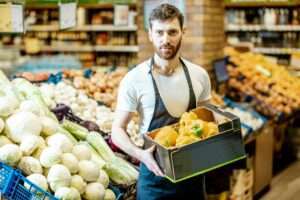 Worker with vegetables in the supermarket