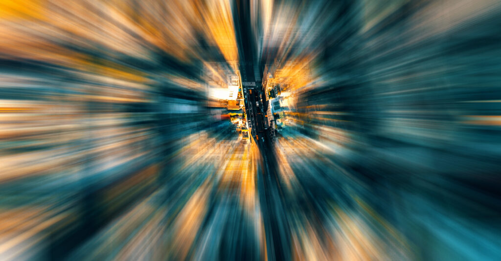 Webdesign Hannover - Luftaufnahme einer städtischen Straße mit Gebäuden, mit einem radialen Unschärfeeffekt, der ein Gefühl von Bewegung erzeugt und die Aufmerksamkeit auf das Zentrum lenkt - ideal für die Visualisierung von ladezeit optimierung in städtischen Umgebungen. Local SEO Agentur Hannover.