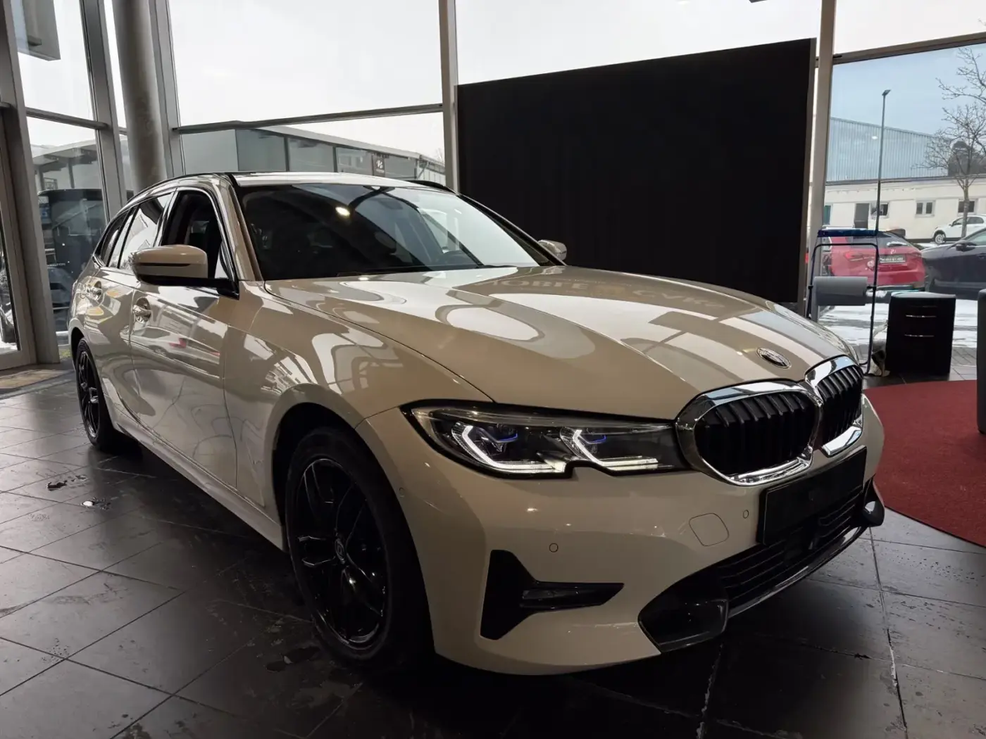 Webdesign Hannover – Ein beiger BMW-Kombi steht in einem dunkel gefliesten Ausstellungsraum, perfekt positioniert, um Autos zu fotografieren, mit großen Fenstern und Autos im Blickfeld. Local SEO Agentur Hannover. Webdesign Hannover - Ein beiger BMW-Kombi steht in einem dunkel gefliesten Ausstellungsraum, perfekt positioniert, um Autos zu fotografieren, mit großen Fenstern und Autos im Blickfeld. Local SEO Agentur Hannover.