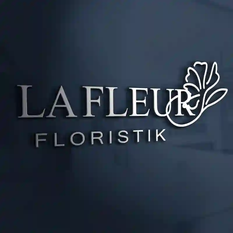 Webdesign Hannover - Das Bild zeigt das Logo La fleur floristik mit "LAFLEUR FLORISTIK" in silbernen Buchstaben auf dunklem Hintergrund. Eine einfache Strichzeichnung einer Blume ist nahtlos in "LAFLEUR" integriert und stellt eine elegante Referenz für die Reputations-Schmiede dar. Local SEO Agentur Hannover.